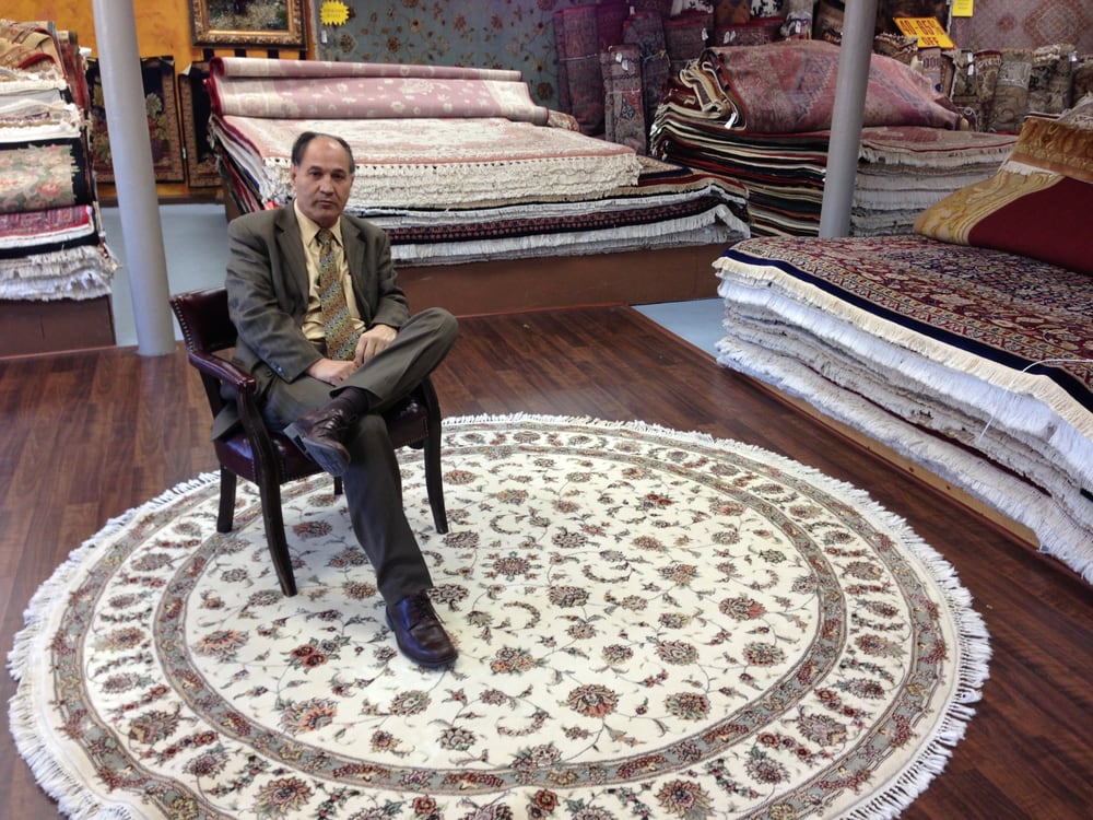Hassan Khoshroo sitting in chair on a rug